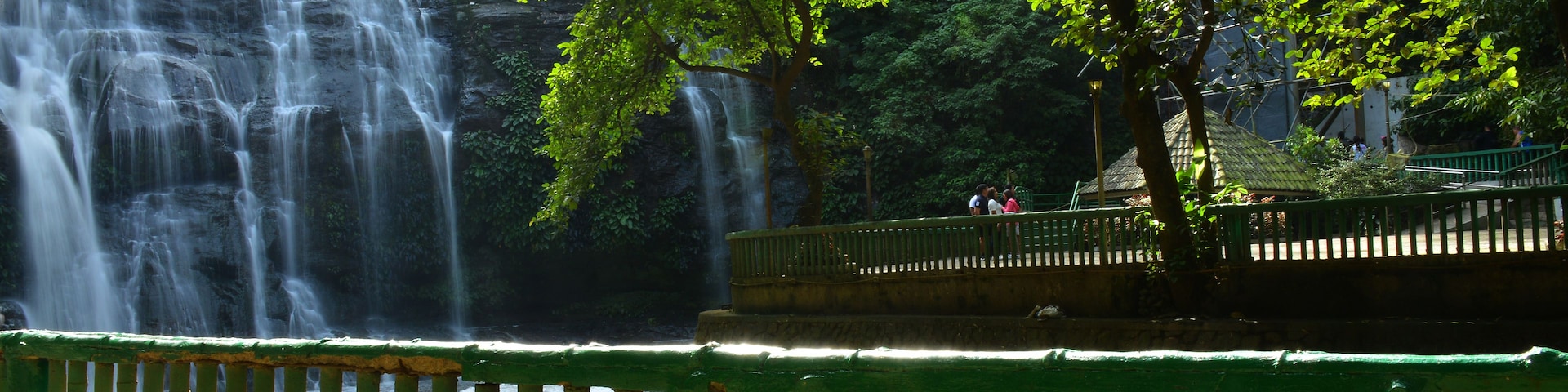 A waterfall, a bridge, and a railing.