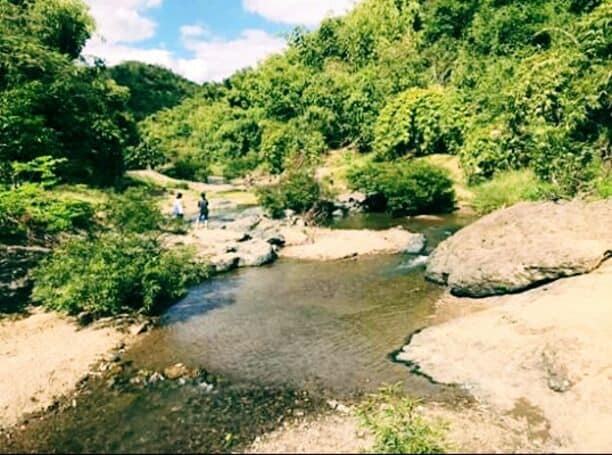 Um rio serpenteando por uma paisagem rochosa, com vegetação densa nas margens.