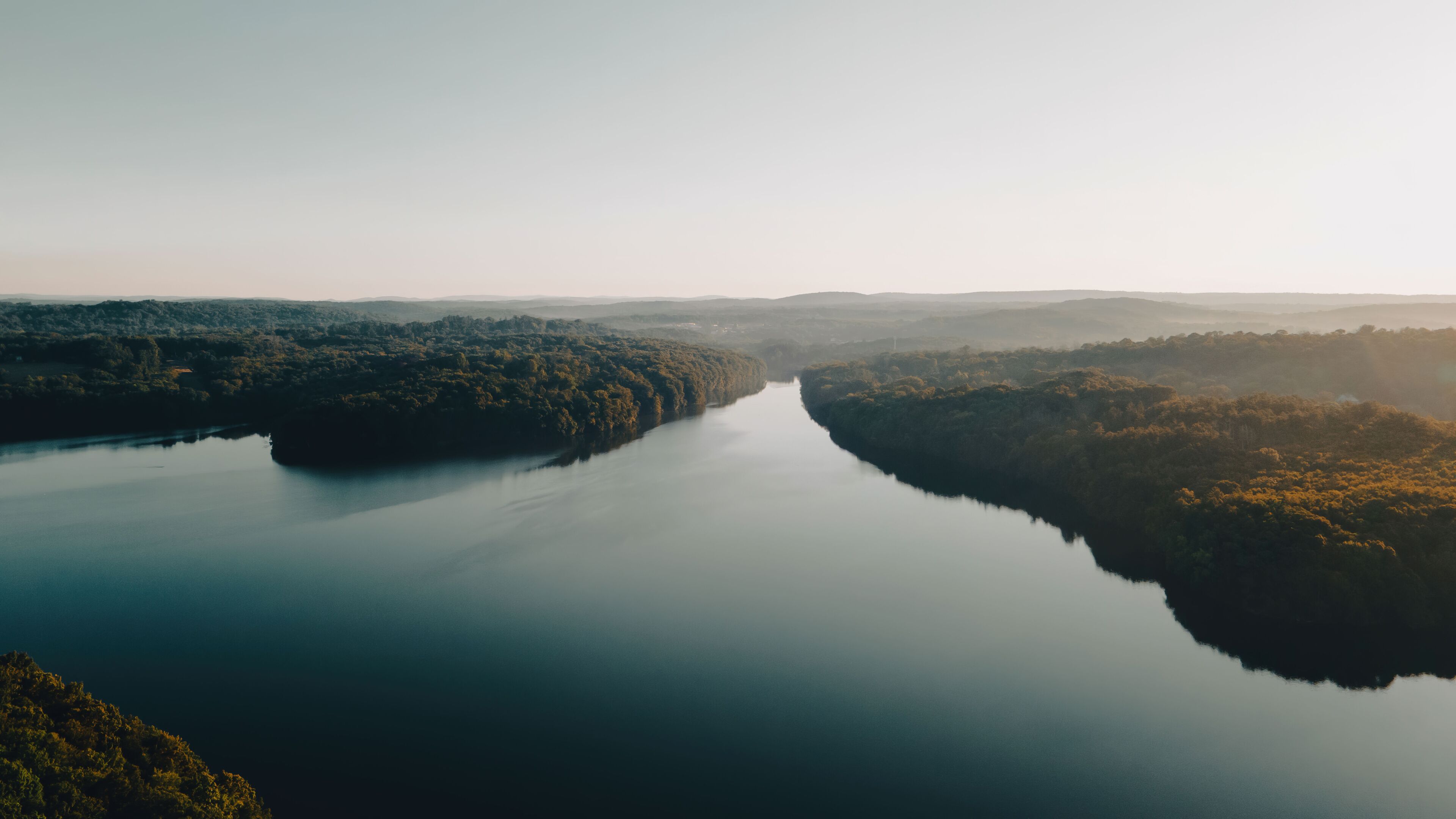 Aerial Photo of a large river surrounded by lush forests in New York. 