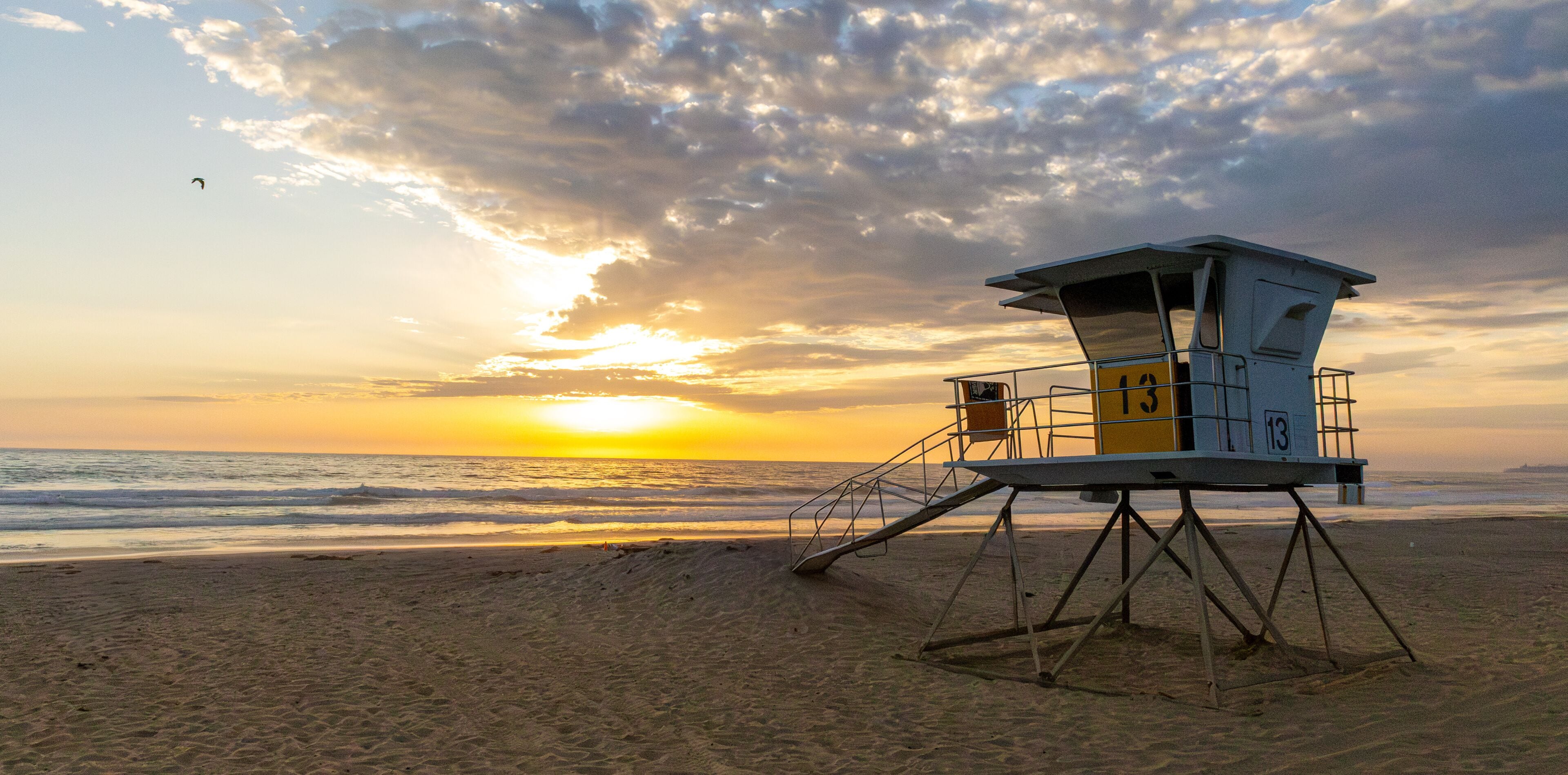 Sun setting over the Pacific Ocean from public lifeguard tower 13 at Mission Beach in San Diego, California, USA taken on June 1, 2025