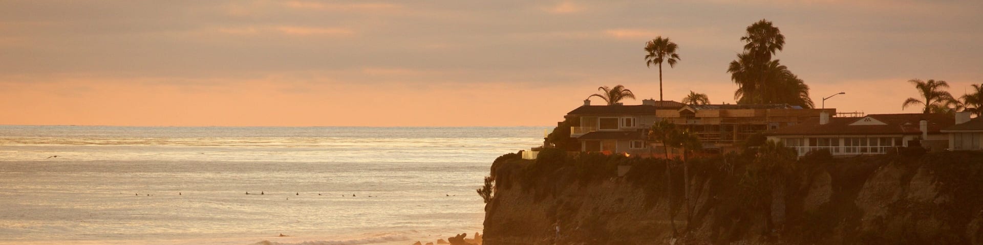 Pacific Beach Park showing surfing, swimming and rugged coastline