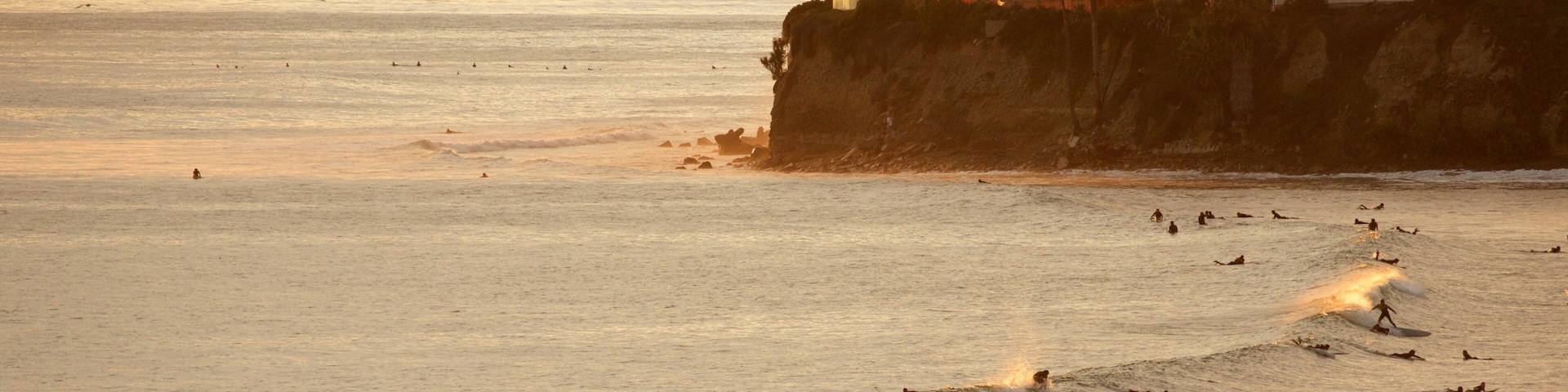 Pacific Beach Park showing surfing, swimming and rugged coastline