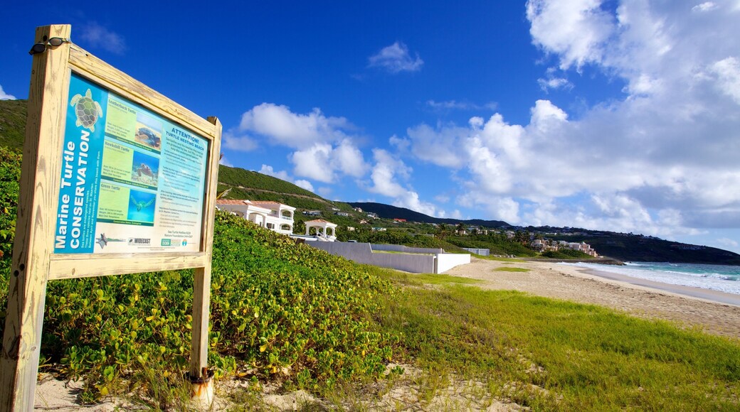 Guana Bay Beach showing signage, landscape views and a sandy beach