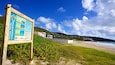 Guana Bay Beach showing landscape views, a sandy beach and signage