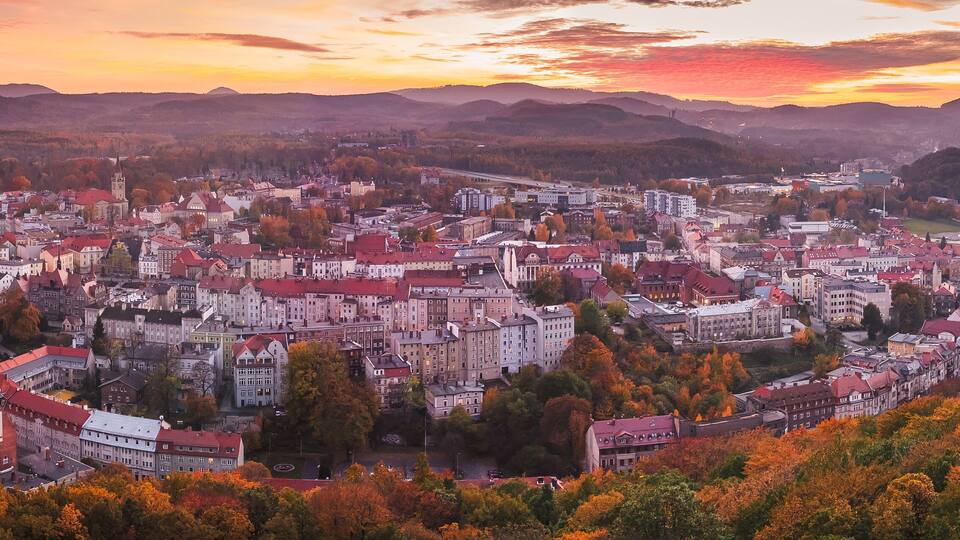 Walbrzych, sunset with a view of the city center and the Walbrzych Mountains. View of the city from the observation tower in Jan Sobieski Park, colorful autumn evening.