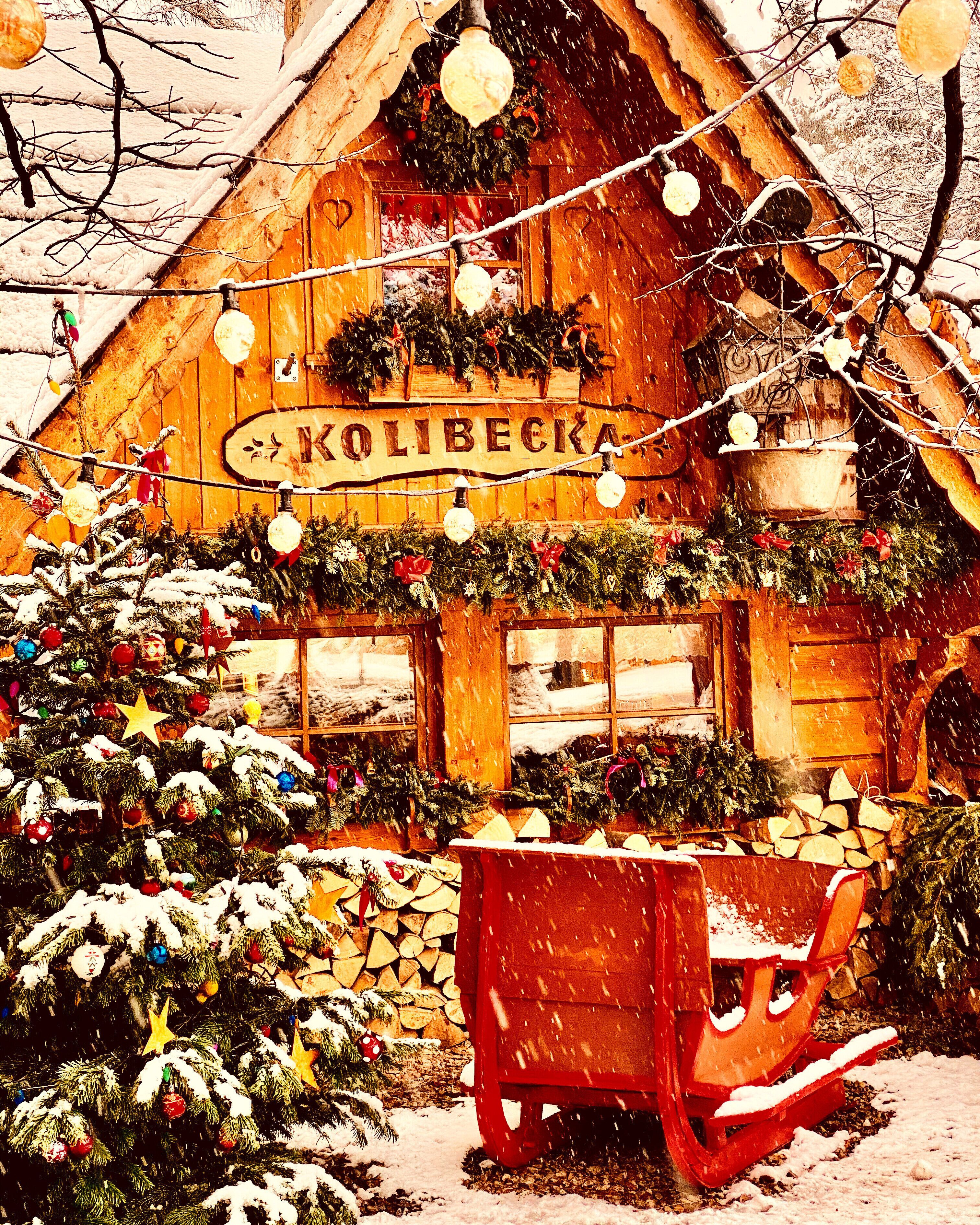 A snow-covered wooden building with a sign reading "KOLIBECKA".