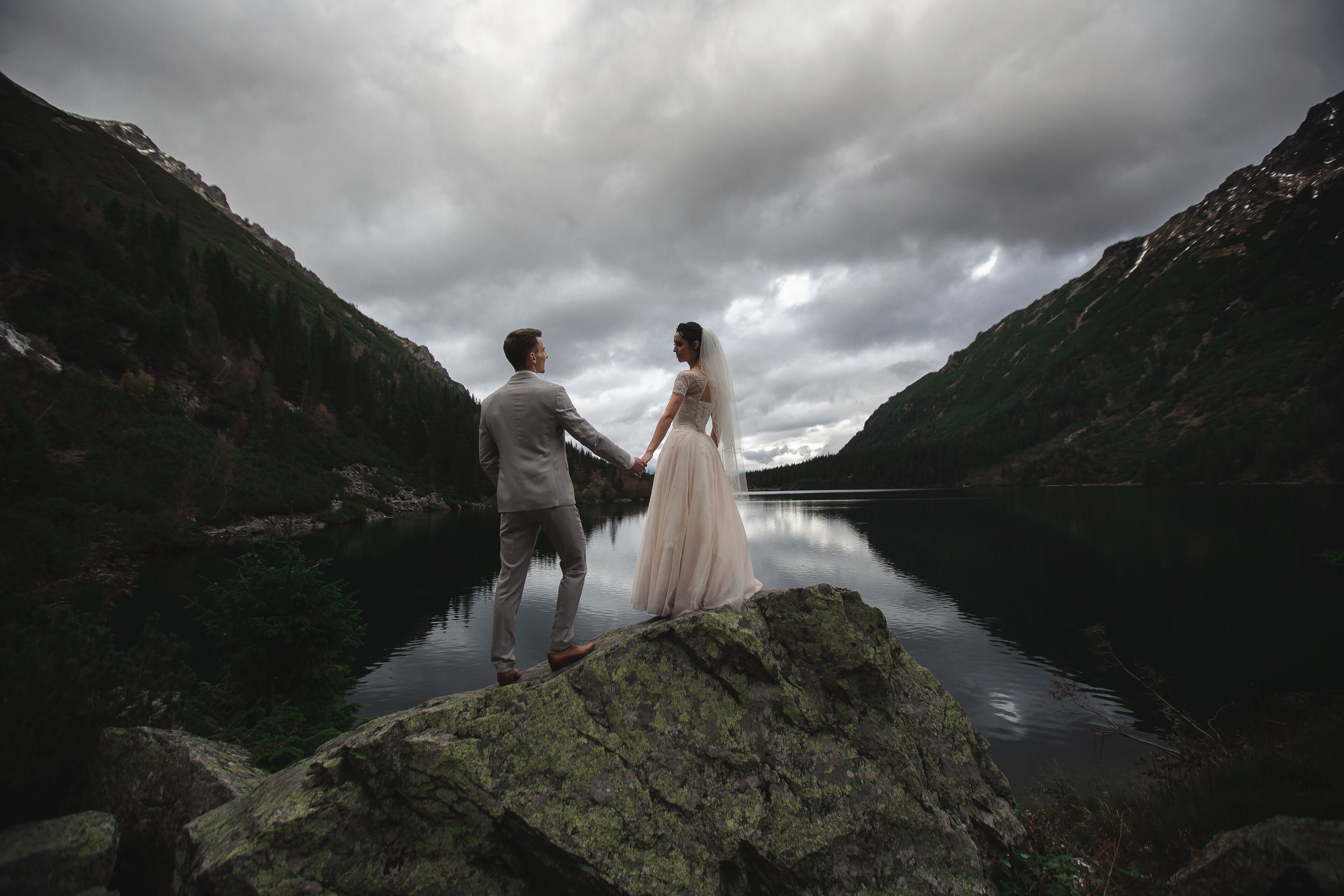 A young wedding couple enjoys a mountain view on the shore of a lake Morskie Oko.