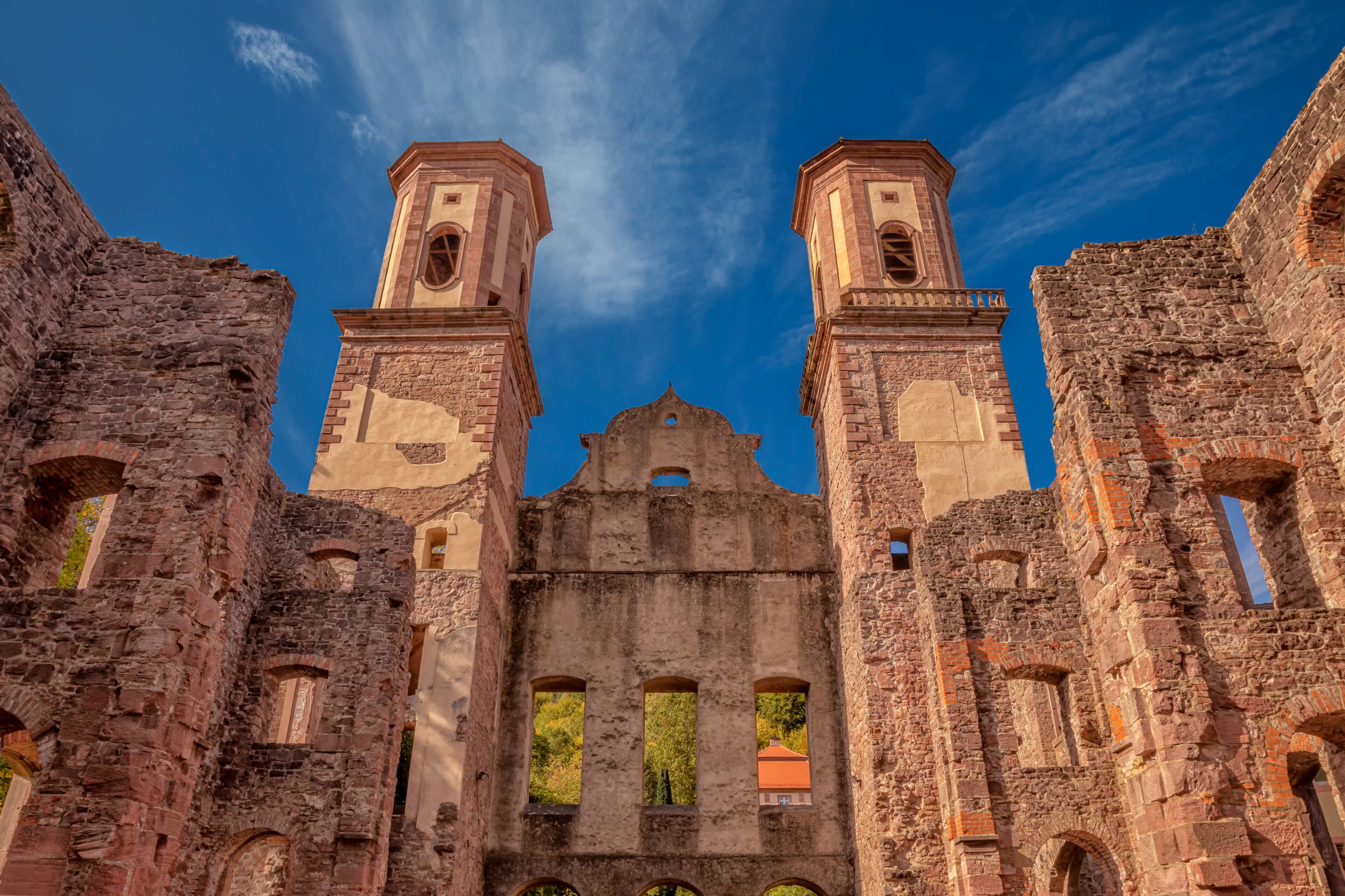 An ancient stone building with two bell towers and arched windows.