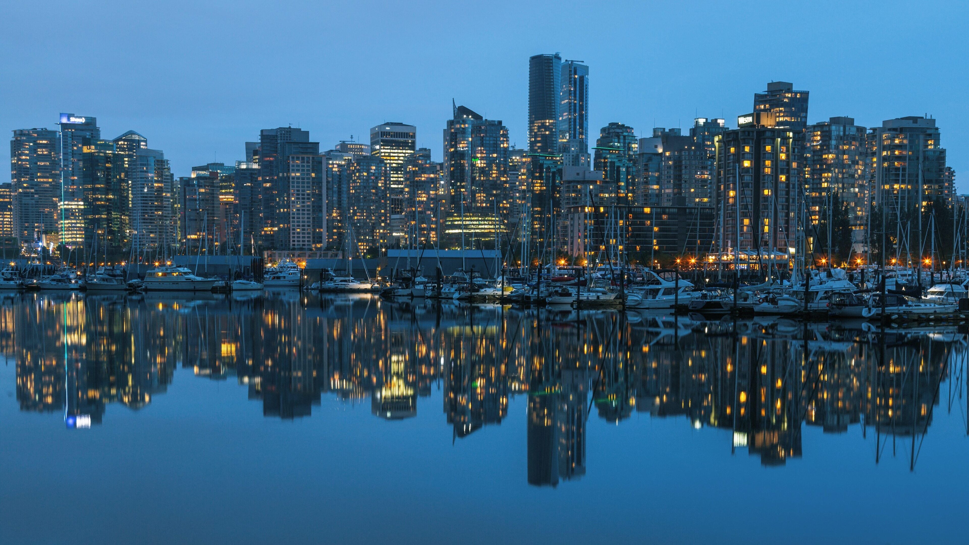 Stunning view of city skyline reflected in water at Stanley Park, Vancouver, showcasing the vibrant life after sunset