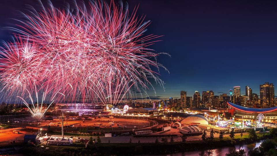 A city skyline with a large stadium and fireworks display.
