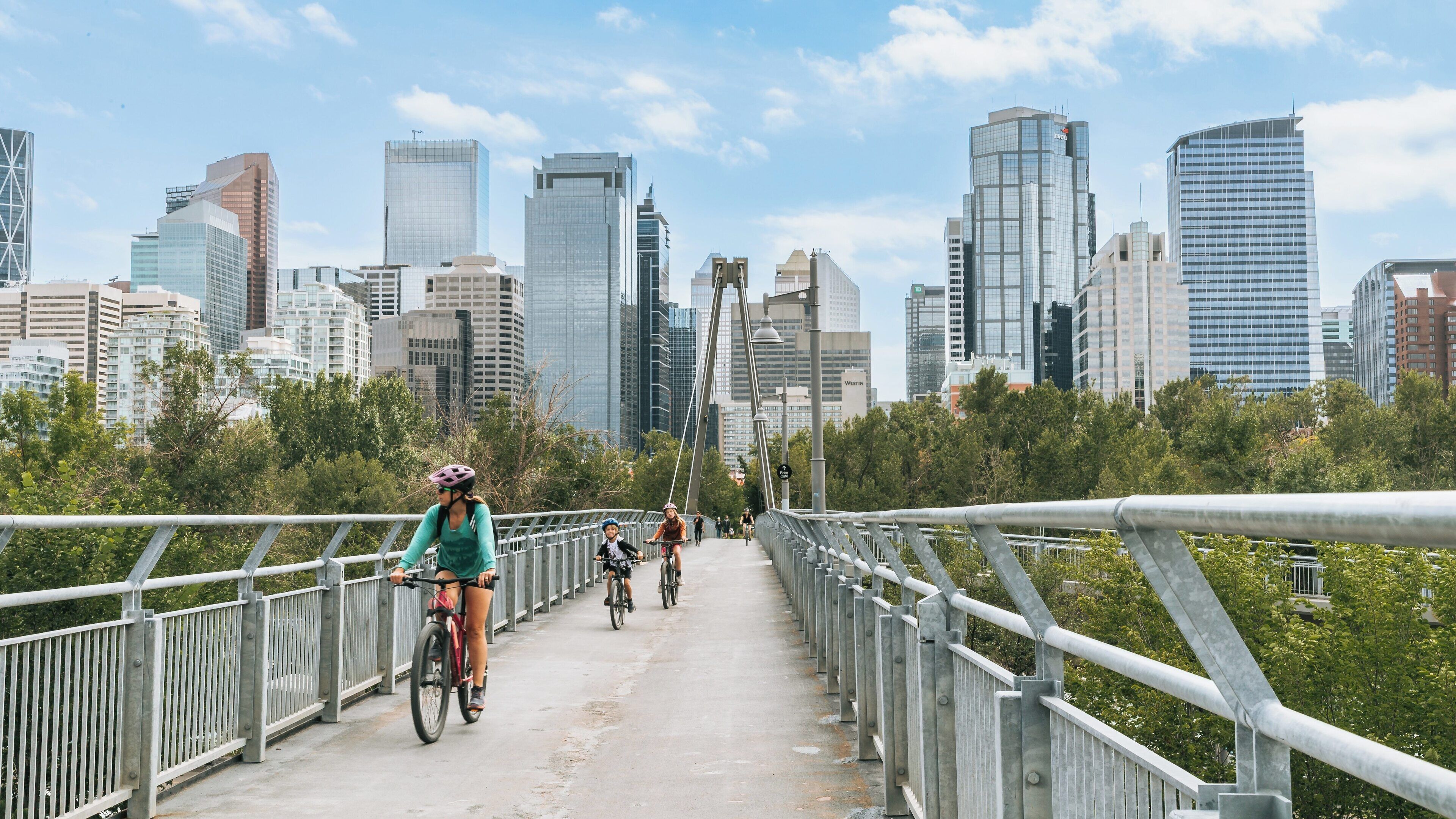 Biking through Prince's Island Park in Downtown Calgary, Alberta with city skyline in the background