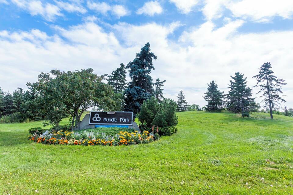 Placa de Rundle Park, com área gramada e árvores ao fundo.