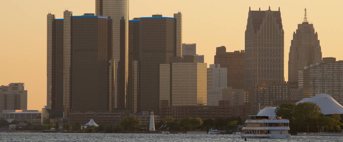 A city skyline with tall buildings and a body of water in the foreground.