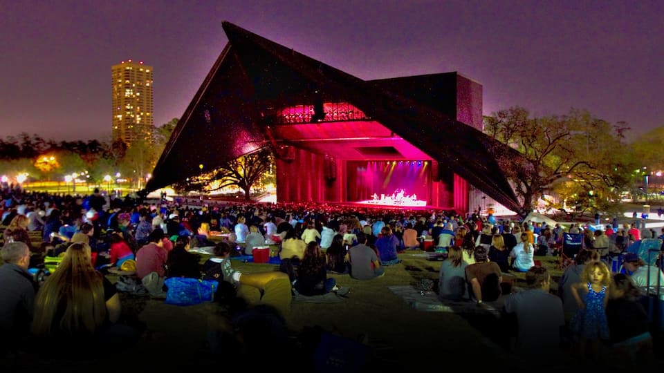 Crowd enjoying a live performance at Hermann Park's outdoor theater in Houston, Texas during a vibrant evening event