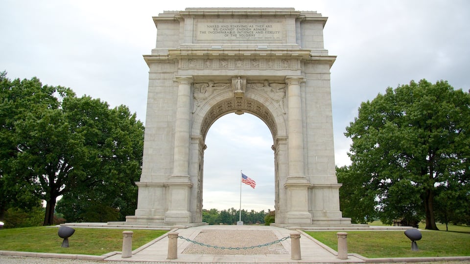 A large stone arch monument with an American flag in front.