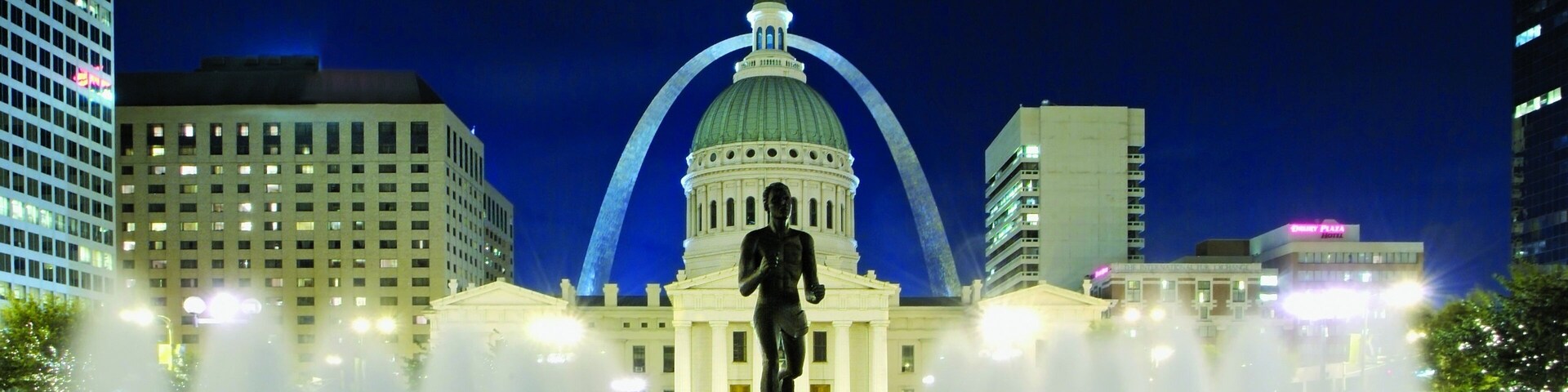 Vibrant evening view of Gateway Arch National Park with illuminated fountains in St. Louis, Missouri
