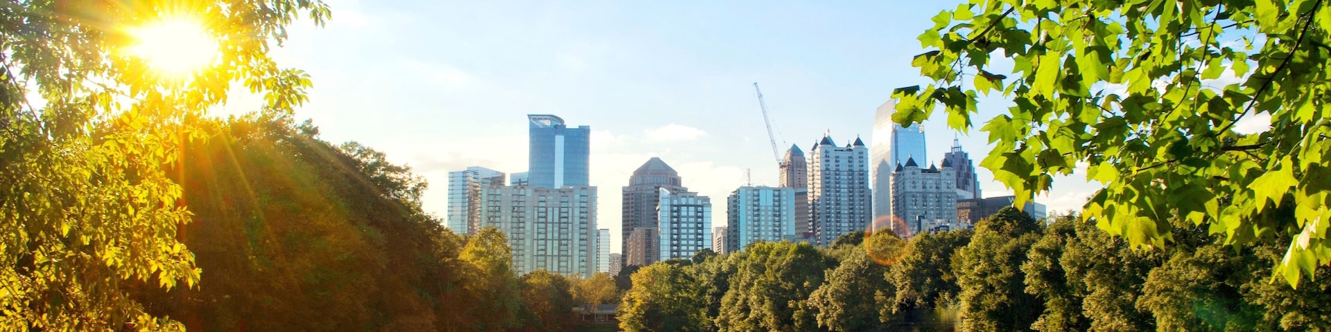 A lake with a city skyline in the background, surrounded by trees.