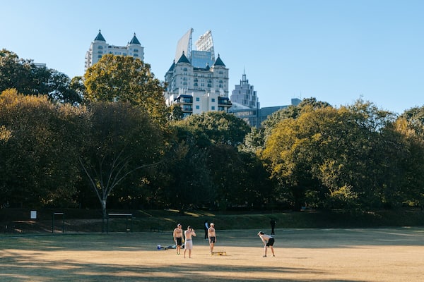 Piedmont Park featuring a garden as well as a small group of people