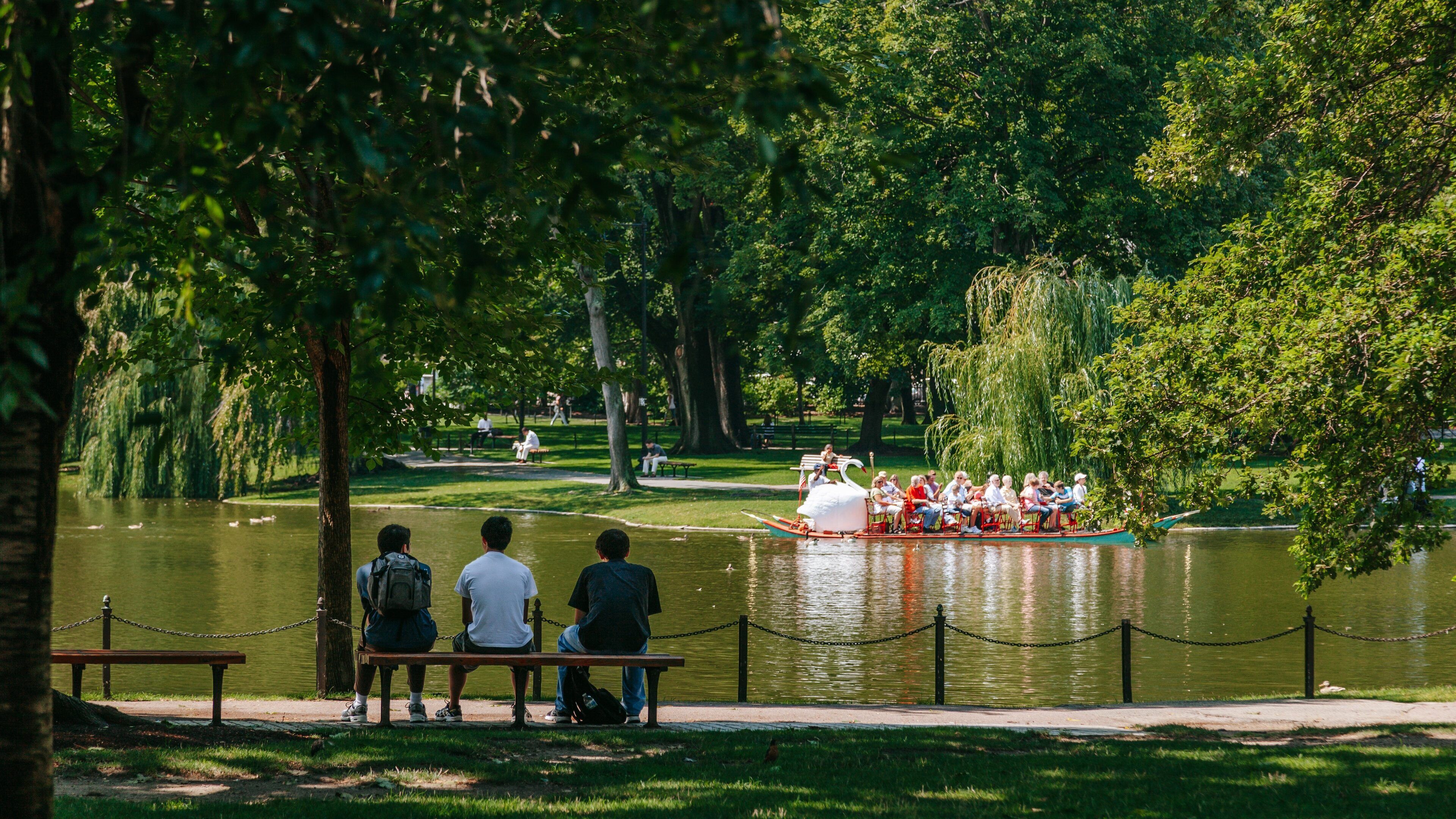 Boston Common featuring a garden and a pond as well as a small group of people