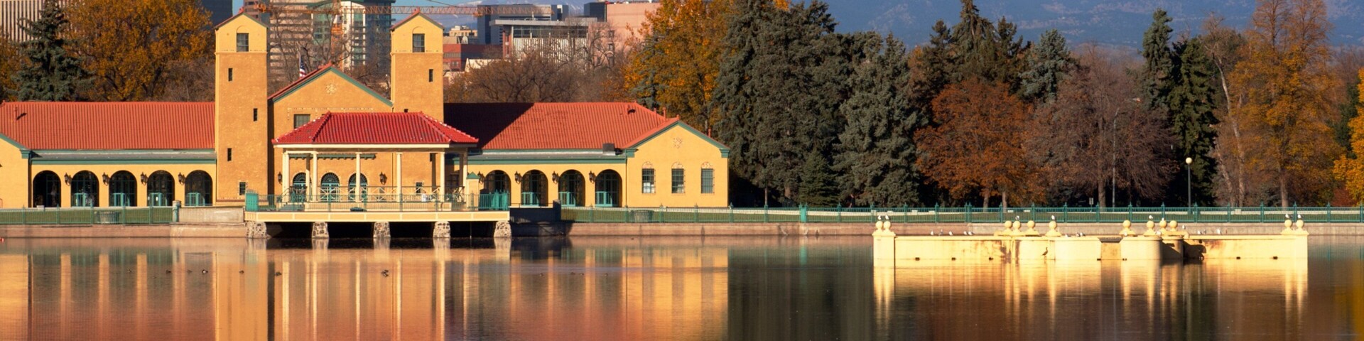 Beautiful autumn view of City Park in Denver, Colorado with serene lake reflections and surrounding mountains