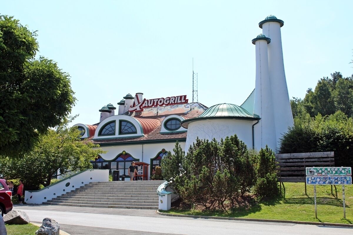 A building with a sign reading "AUTOGRILL" and a tall chimney.