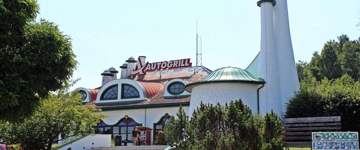A building with a sign reading "AUTOGRILL" and a tall chimney.