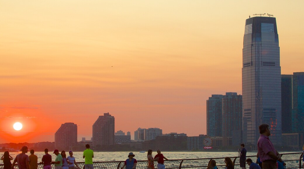 Battery Park som visar en stad, en hamn eller havsbukt och en solnedgång