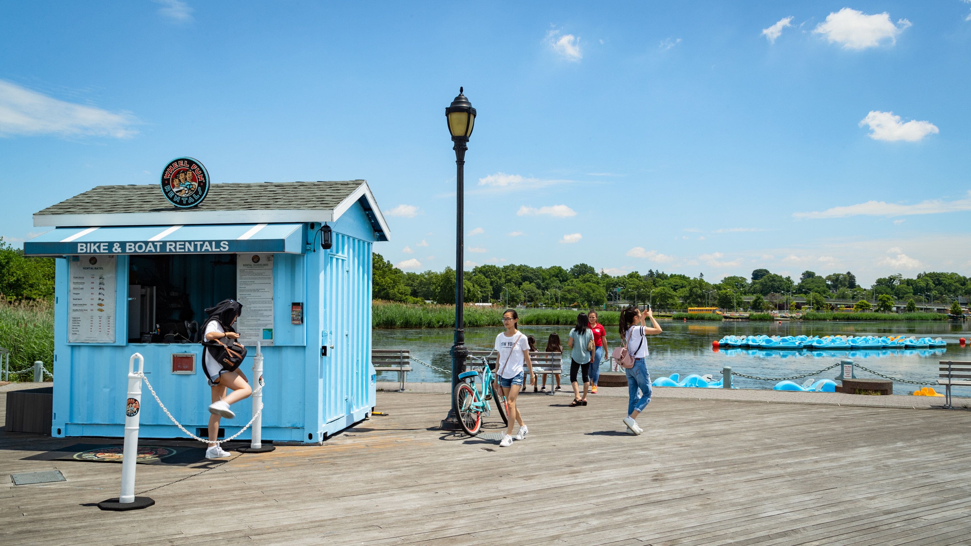 Flushing Meadows-Corona Park featuring a lake or waterhole as well as a small group of people