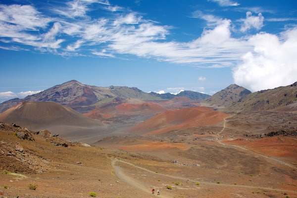 A rugged mountainous landscape with winding roads and sparse vegetation.