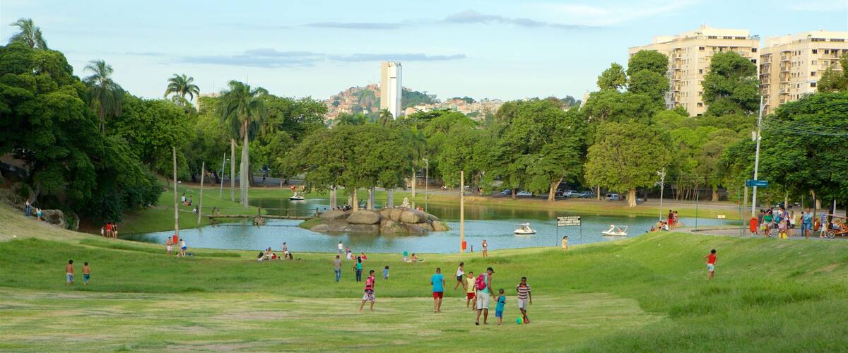 A park with a lake, boats, and people.