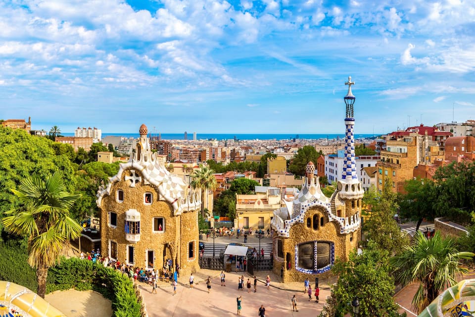 Une vue panoramique d’une ville à l’architecture particulière, avec notamment une tour aux motifs bleus et blancs et un bâtiment surmonté d’un toit en mosaïque.