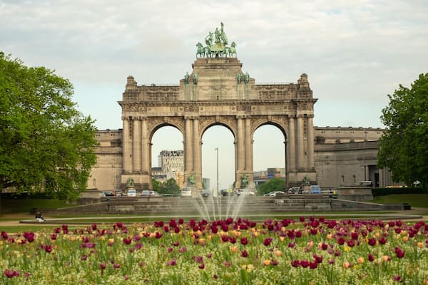 Ein großer, steinerner Bogen mit Statuen darauf, umgeben von einem Tulpenfeld.