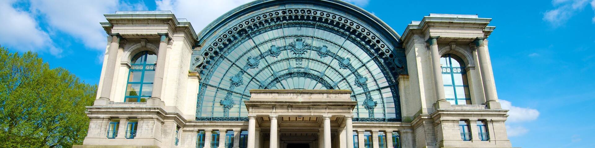 A grand building with a large arched glass facade and classical columns.