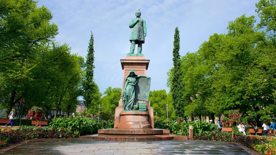 Estátua de um homem num casaco comprido e chapéu, em um pedestal, com uma mulher ao lado.