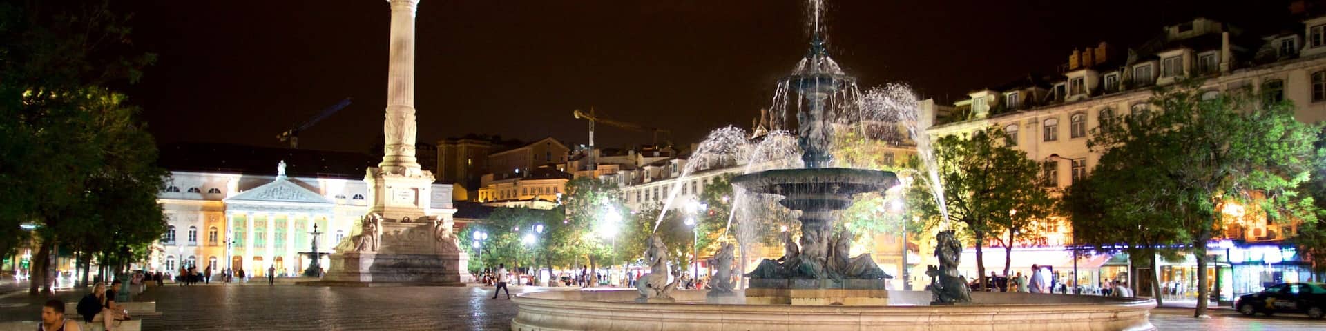 A square with a fountain, a monument, and patterned pavement.