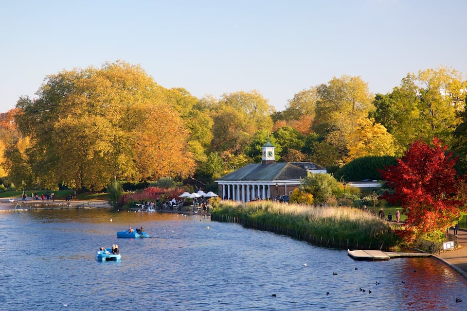 Ein Fluss mit Booten, einem Pavillon und Herbstbäumen.