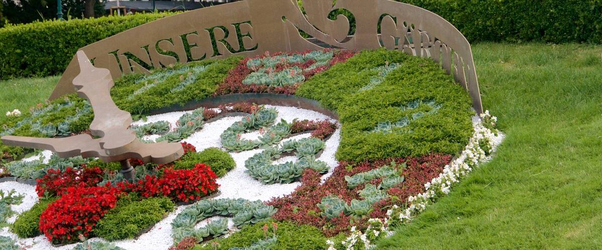 Viennese City Park featuring a garden, flowers and signage