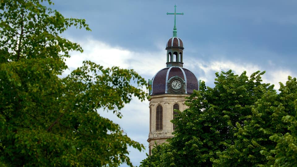 Un campanile con un orologio e una croce.