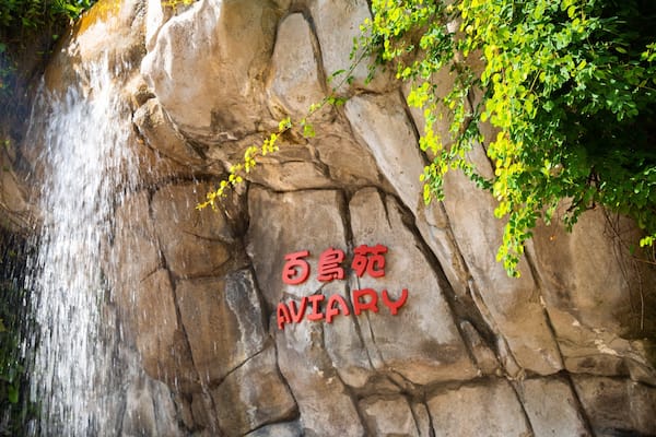 A waterfall cascading down a rocky cliff with Chinese characters on the rock face.