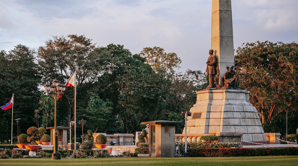 Rizal Park showing a garden, a statue or sculpture and a sunset