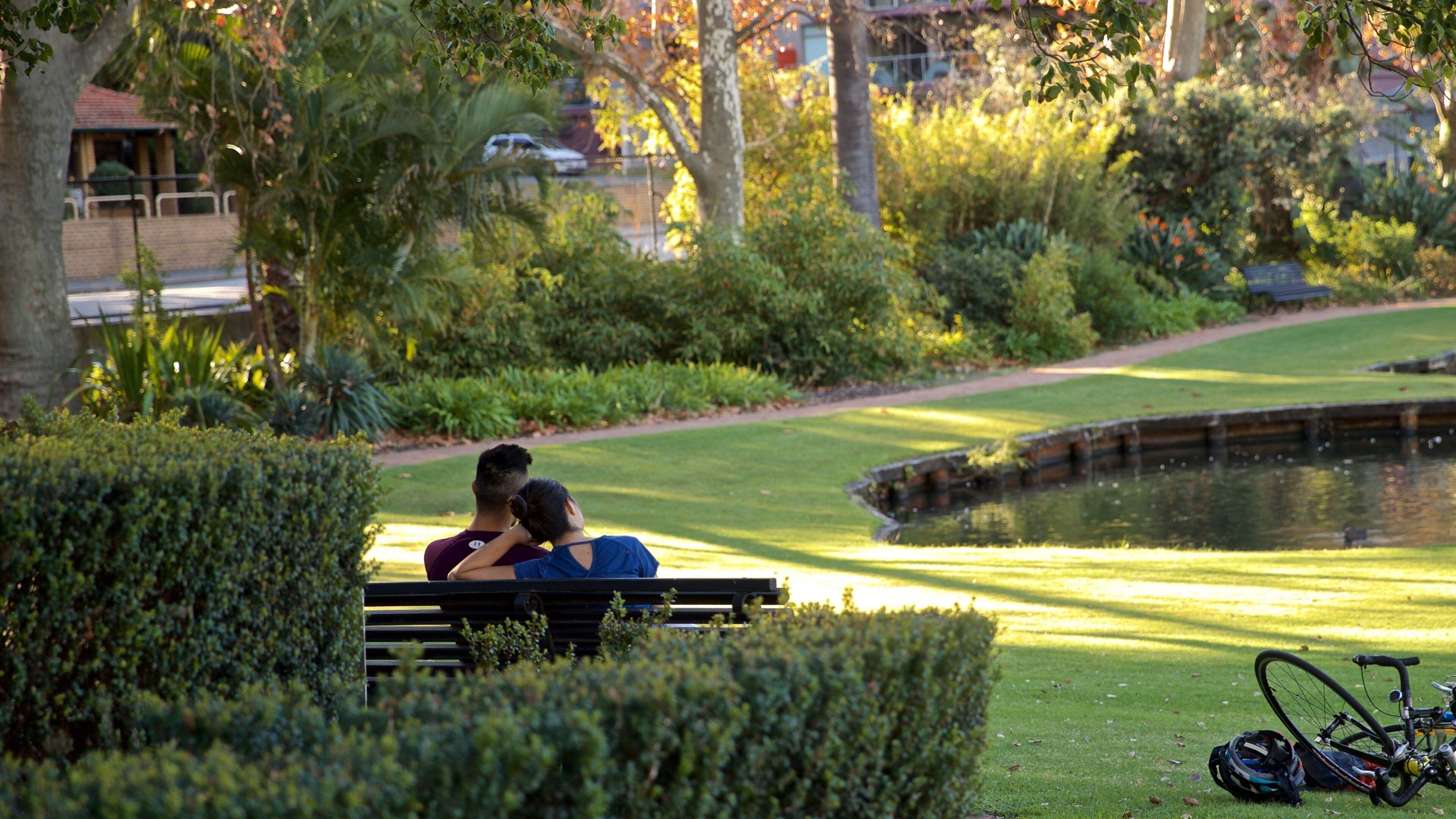 Queens Gardens featuring a pond and a garden as well as a couple