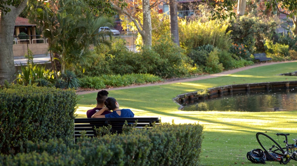 Queens Gardens featuring a pond and a garden as well as a couple
