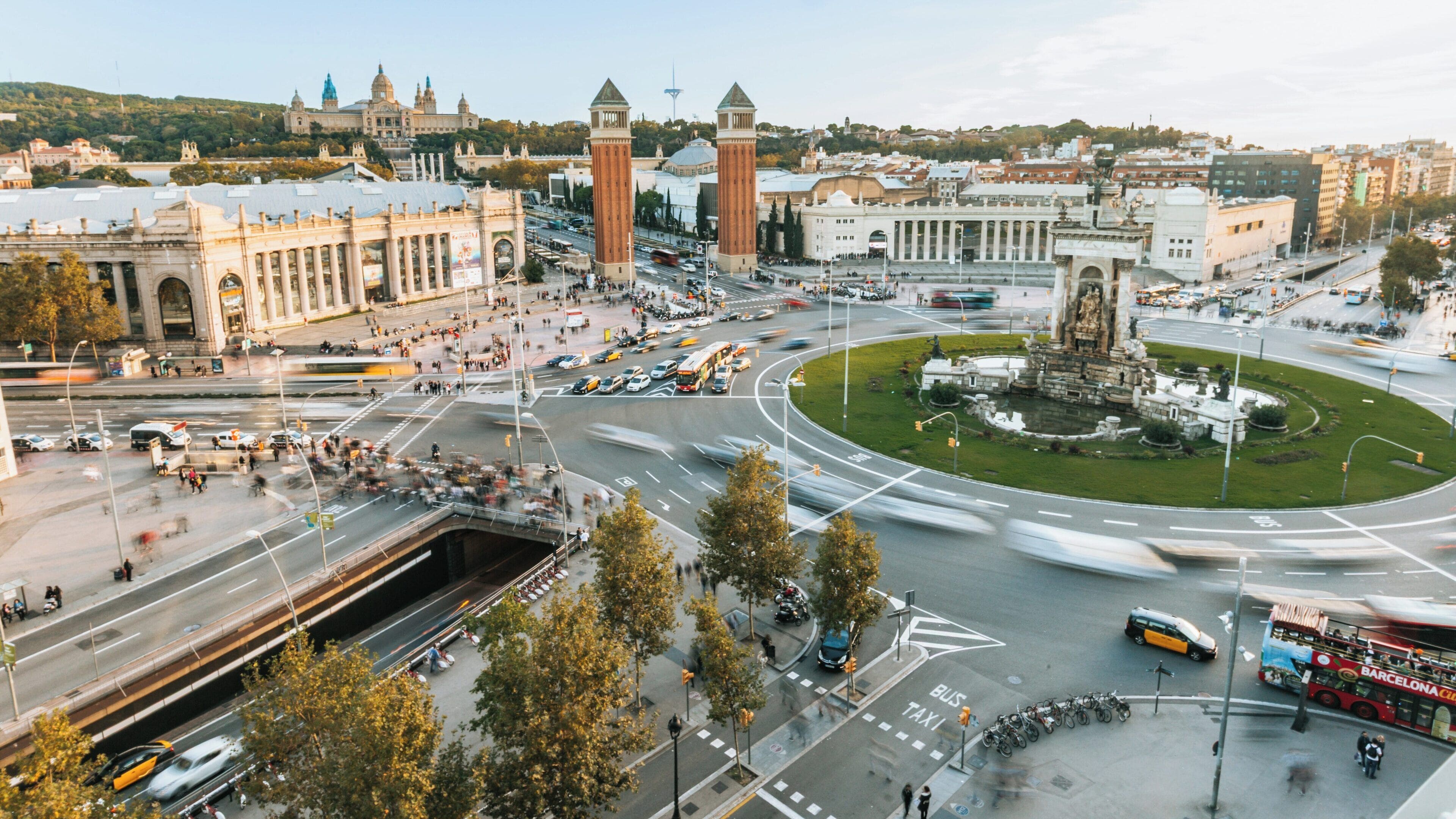 Vibrant atmosphere at Plaça d'Espanya in Sants-Montjuïc, Barcelona, showcasing historical architecture and bustling activity