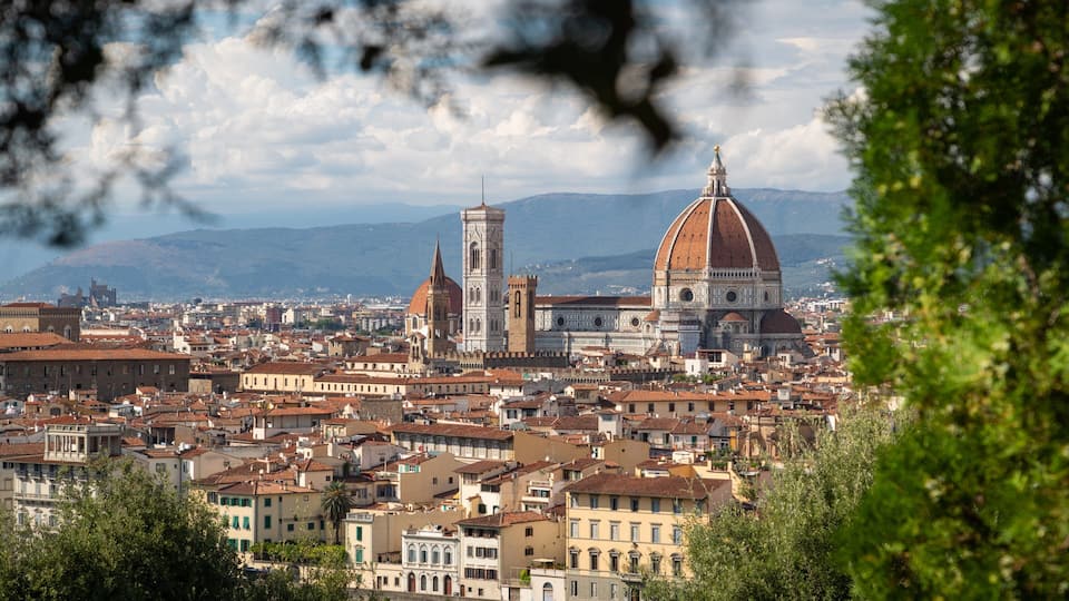 A cityscape with prominent historical architecture, including a large dome and a bell tower.