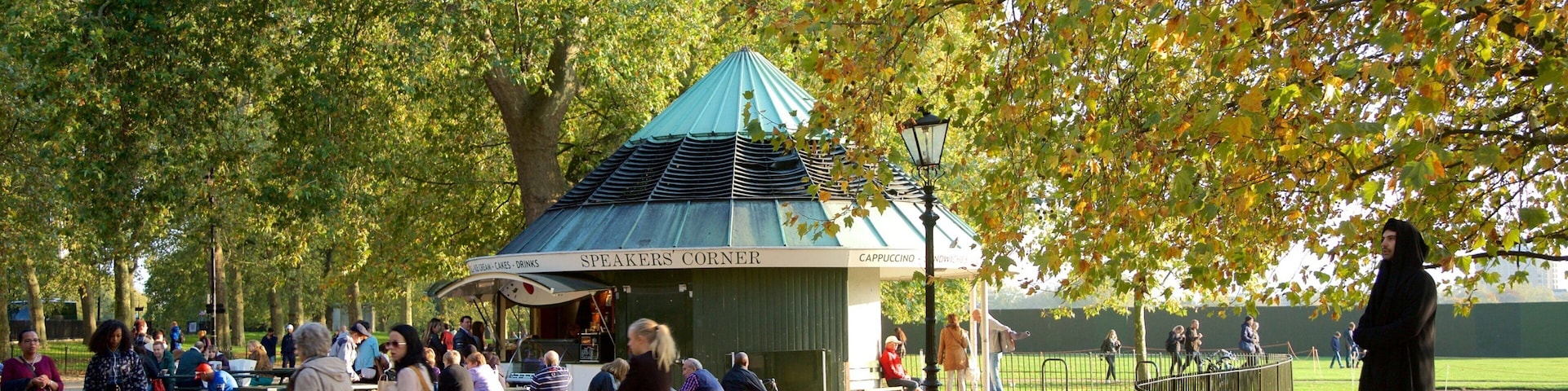 Hyde Park Corner which includes street performance and a garden as well as a small group of people
