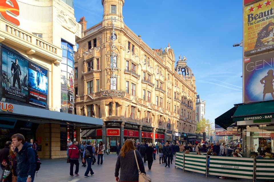 Eine belebte Straße mit historischen Gebäuden, Kinowerbung und einem Café.