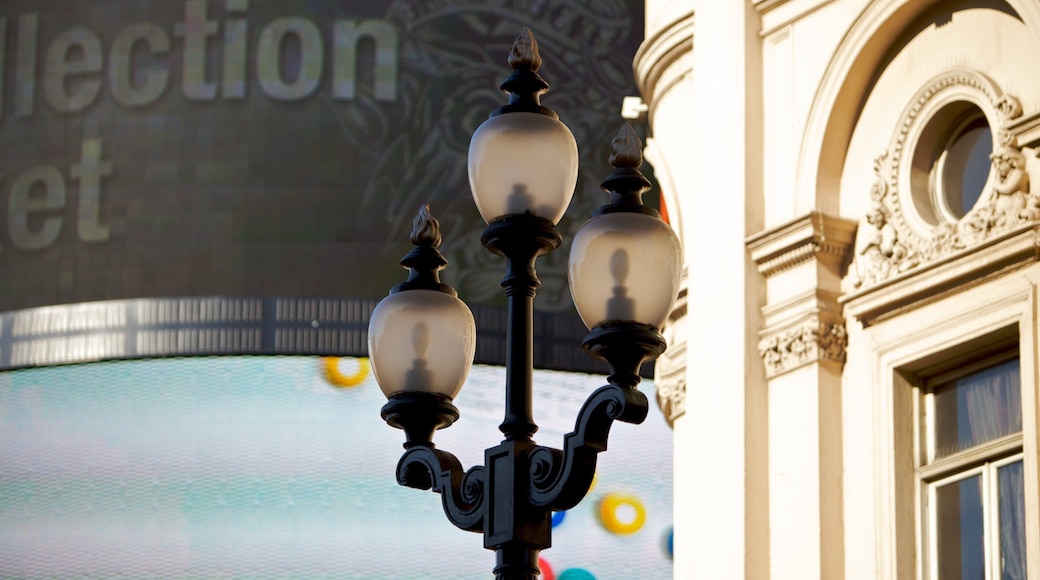 Piccadilly Circus lamp post surrounded by vibrant displays in London, England during daylight