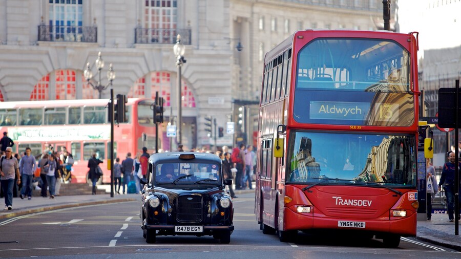 Vibrant activity at Piccadilly Circus with iconic red bus and London taxi in bustling city setting