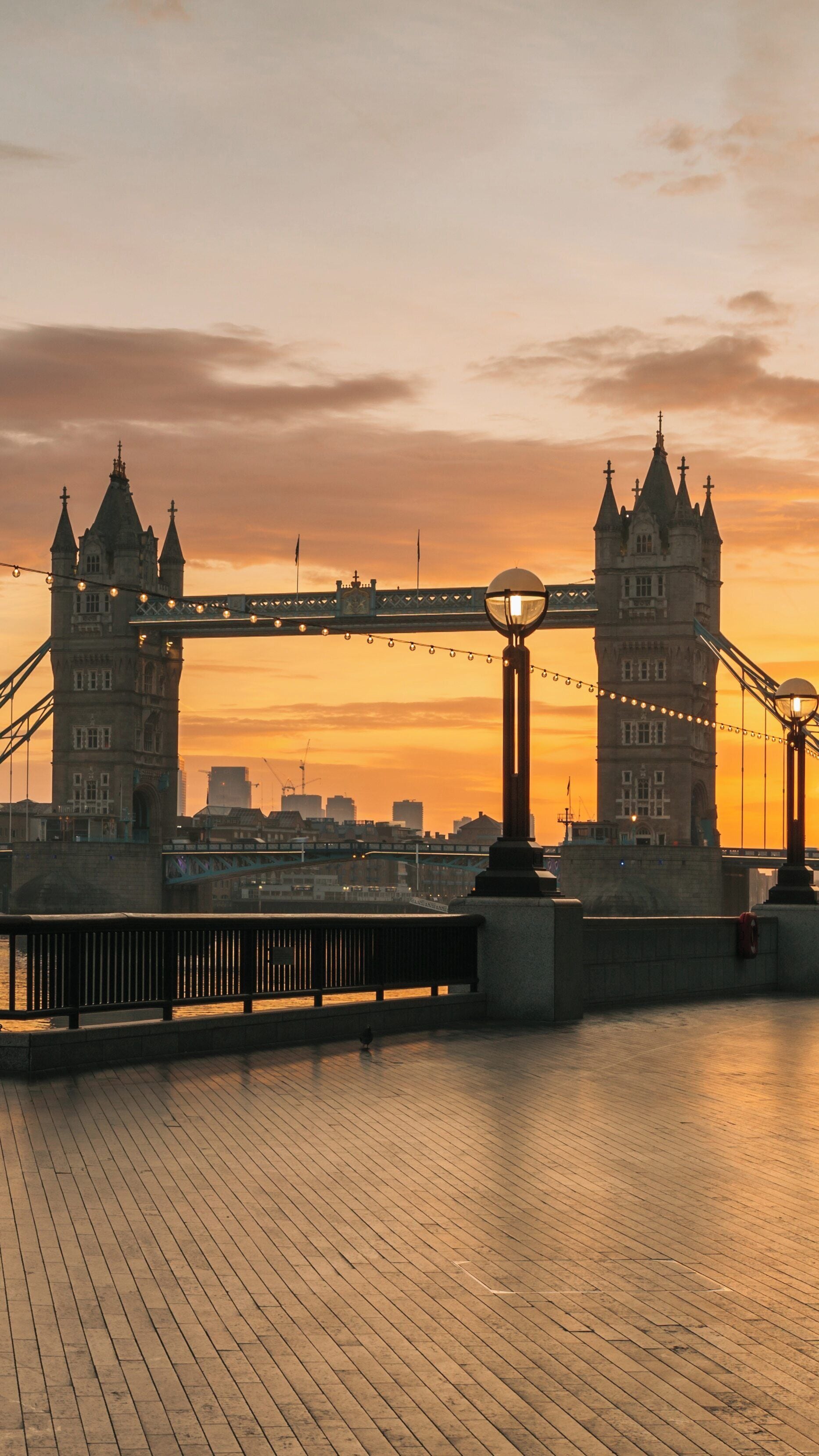 Sunset view of Tower Bridge over River Thames in Tower Hamlets, London with city skyline in the background