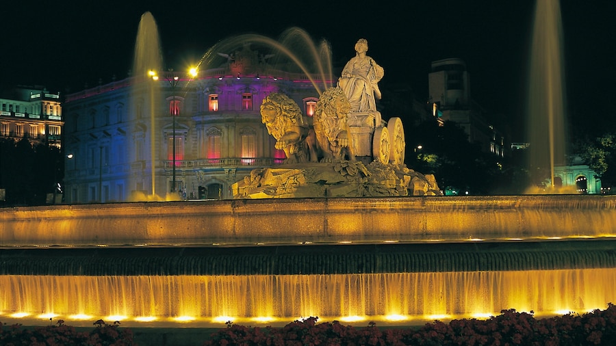 Plaza de Cibeles caracterizando uma praça ou plaza, uma estátua ou escultura e cenas noturnas
